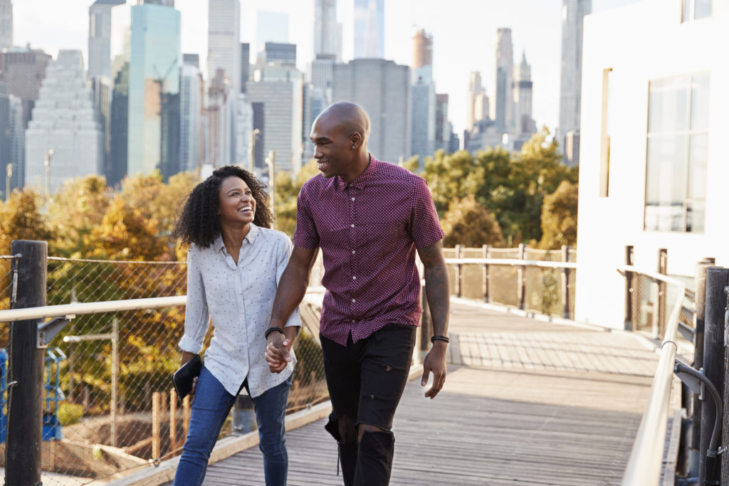 Couple Visiting New York With Manhattan Skyline In Background