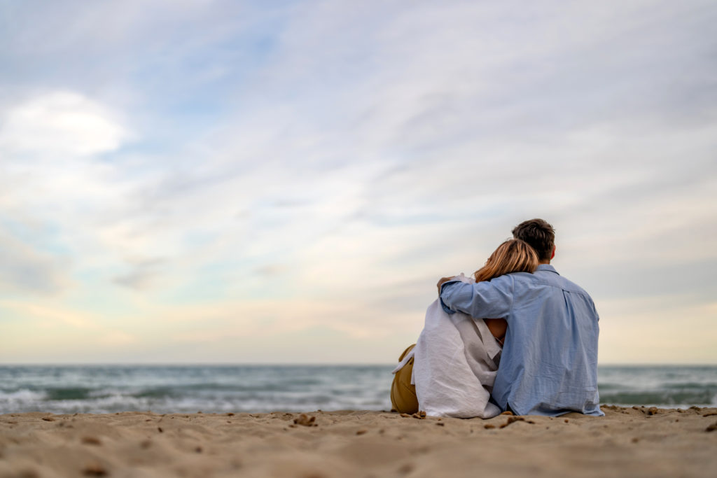 Couple looking to the horizon at the shore