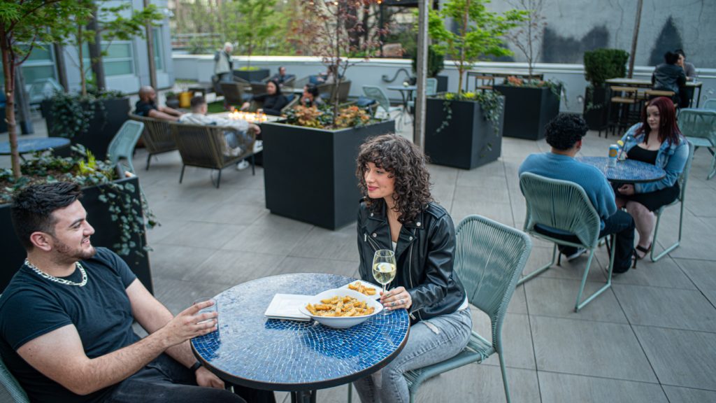 Couple having drinks and food at The Tillary Hotel Garden Bar in Brooklyn